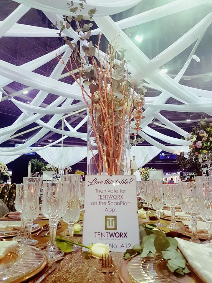 A dried-flower centrepiece on a table under a stretch tent