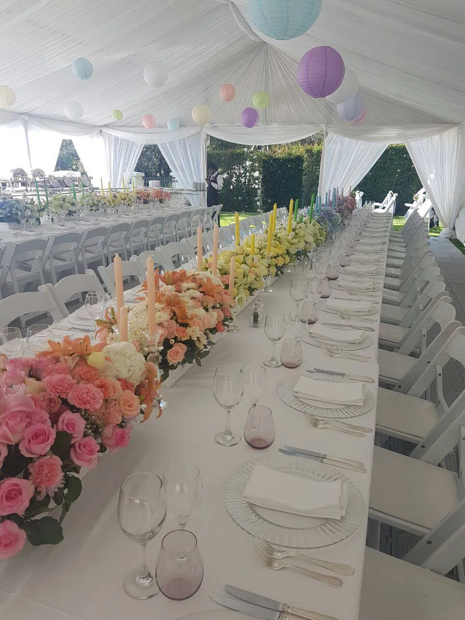 A long table with peach and pink flowers down the centre